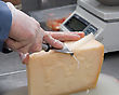 Hand Cutting A Piece Of Cheese.