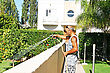 Man Watering The Garden With Hose In Backyard.