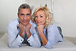 Man And Woman Lying With Their Heads Propped Up On Their Hands - stock photography