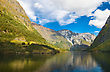 Mountains And Norwegian Fjord In Autumn. Clouds And Blue Sky