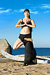 Young Beautiful Woman Is Making Yoga Exercises On The Beach